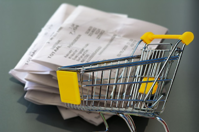 small cart figure with cash receipts in background