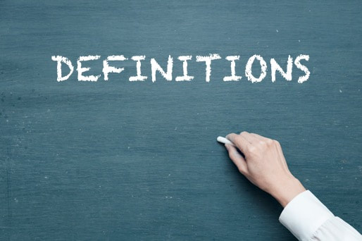 hand writing "DEFINITIONS" in white chalk on chalk board