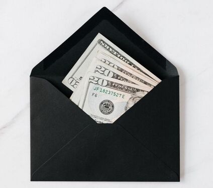 few twenty dollar bills in black envelope