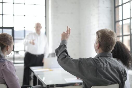 training session with man raising his hand to speak