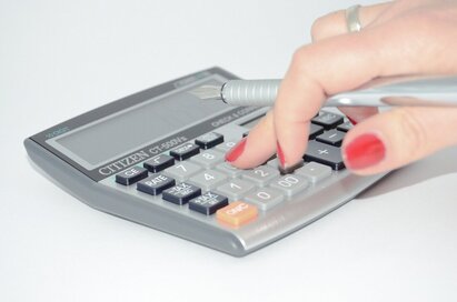 hand typing on calculator